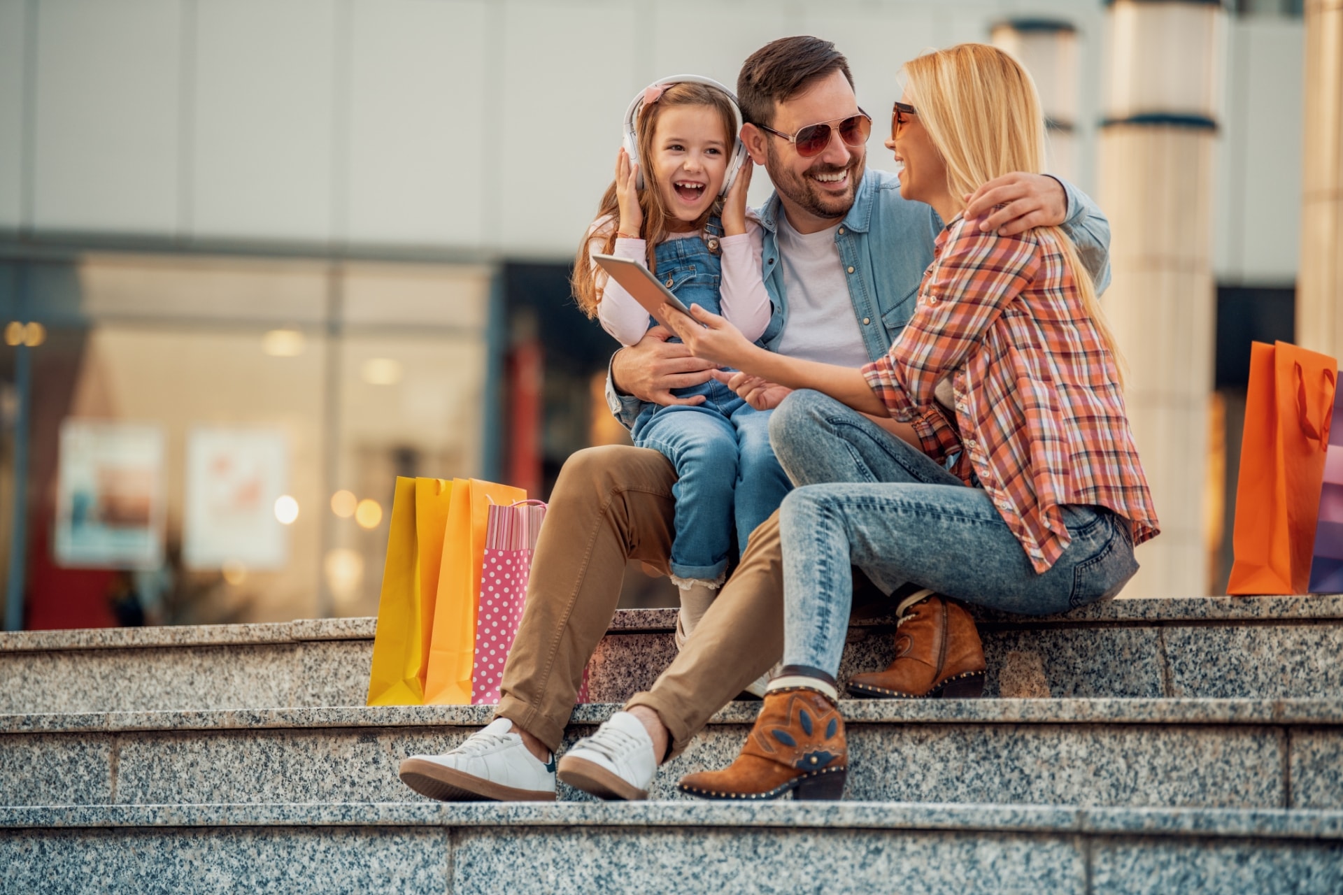 Family sitting on steps with shopping bags laughing